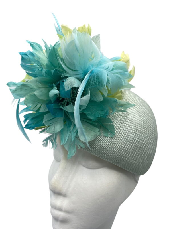 Pale green teardrop base headpiece with an array of stunning complementary feathers to finish.